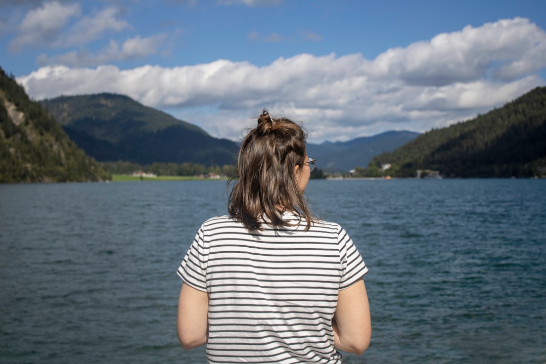 a woman standing in front of a body of water,