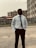 a man in a white shirt and tie standing in a parking lot