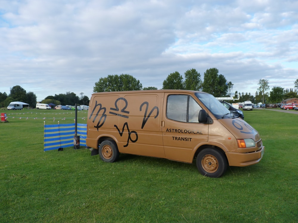 a van parked in a grassy field with a sky background