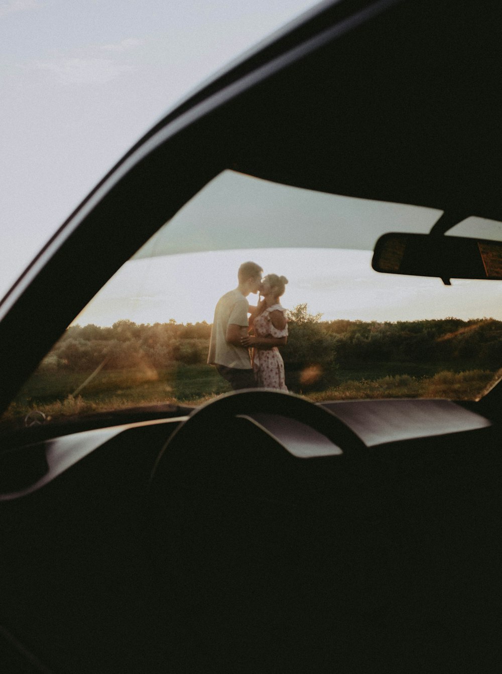 a man and woman standing in the back of a car