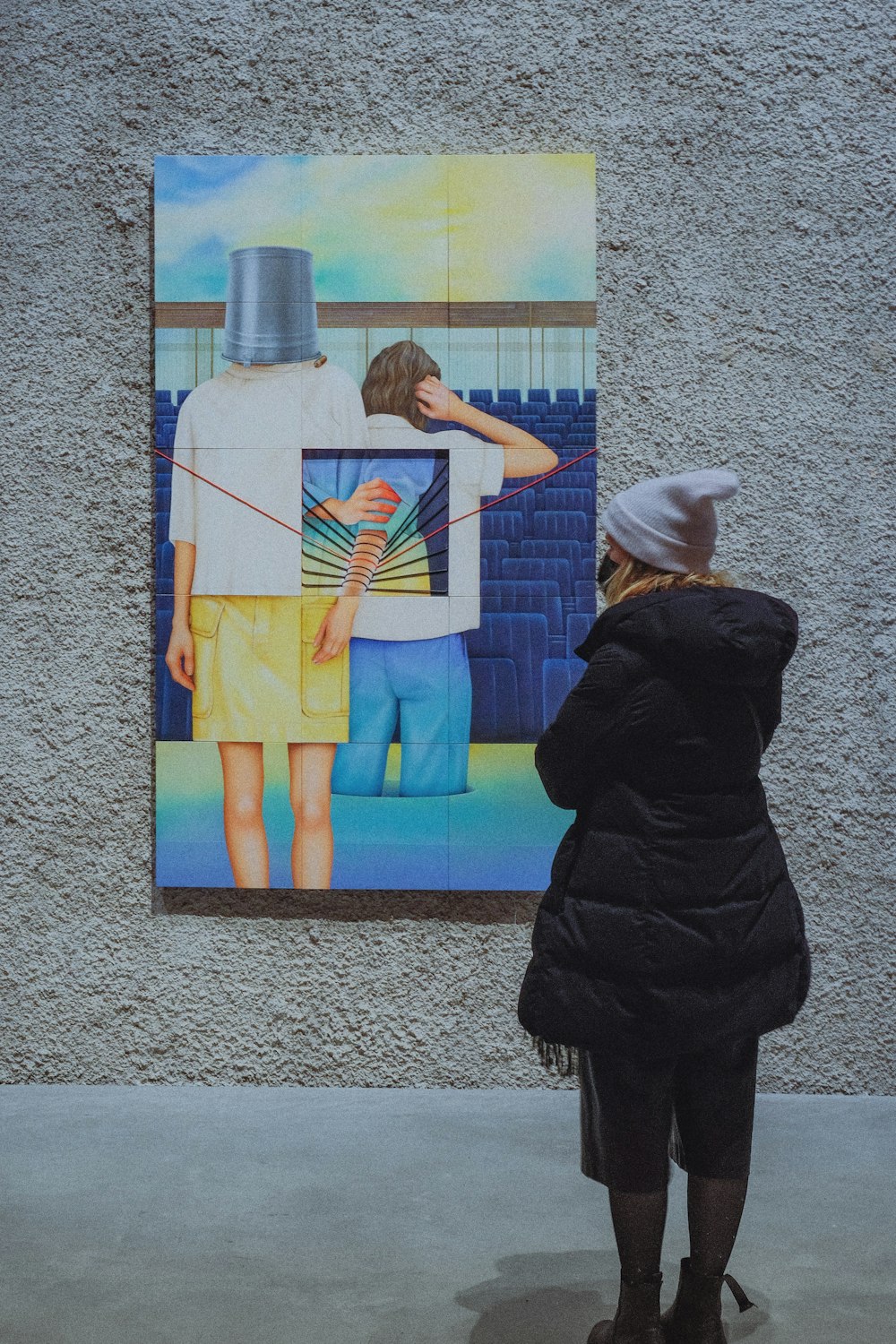 a woman looking at a painting on a wall