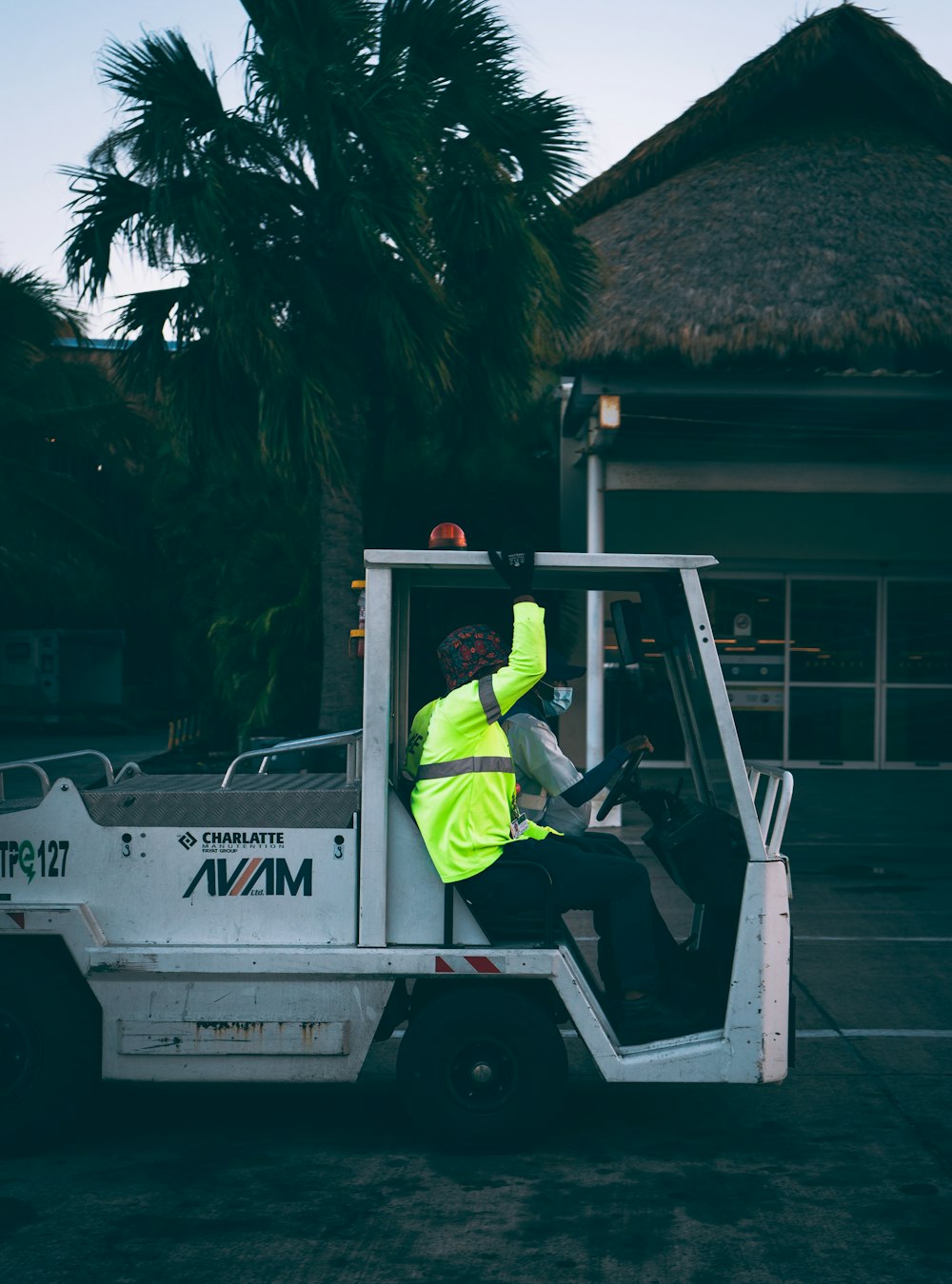 a man in a yellow vest sitting in a white truck