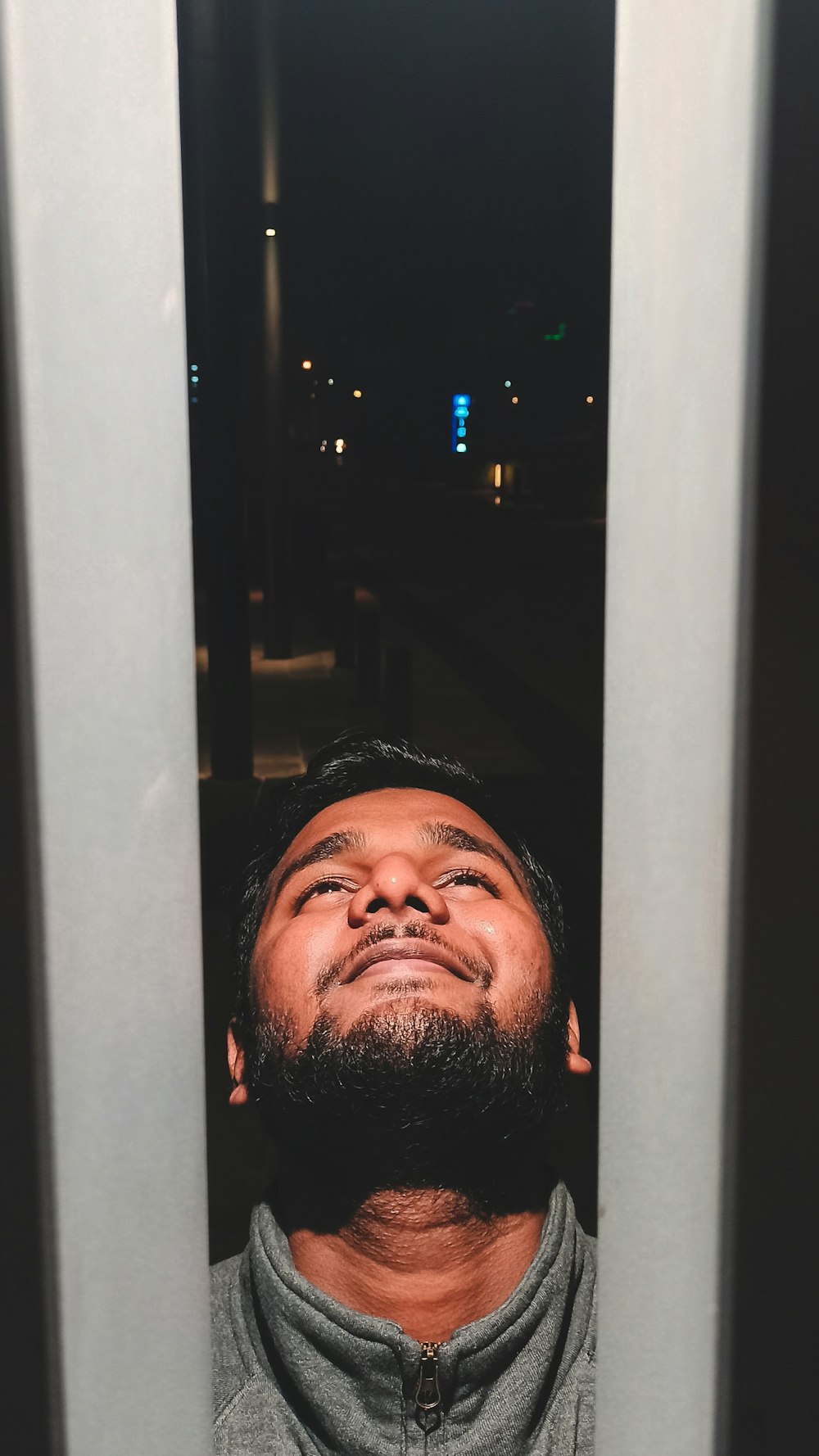 a man with a beard looking up at the sky