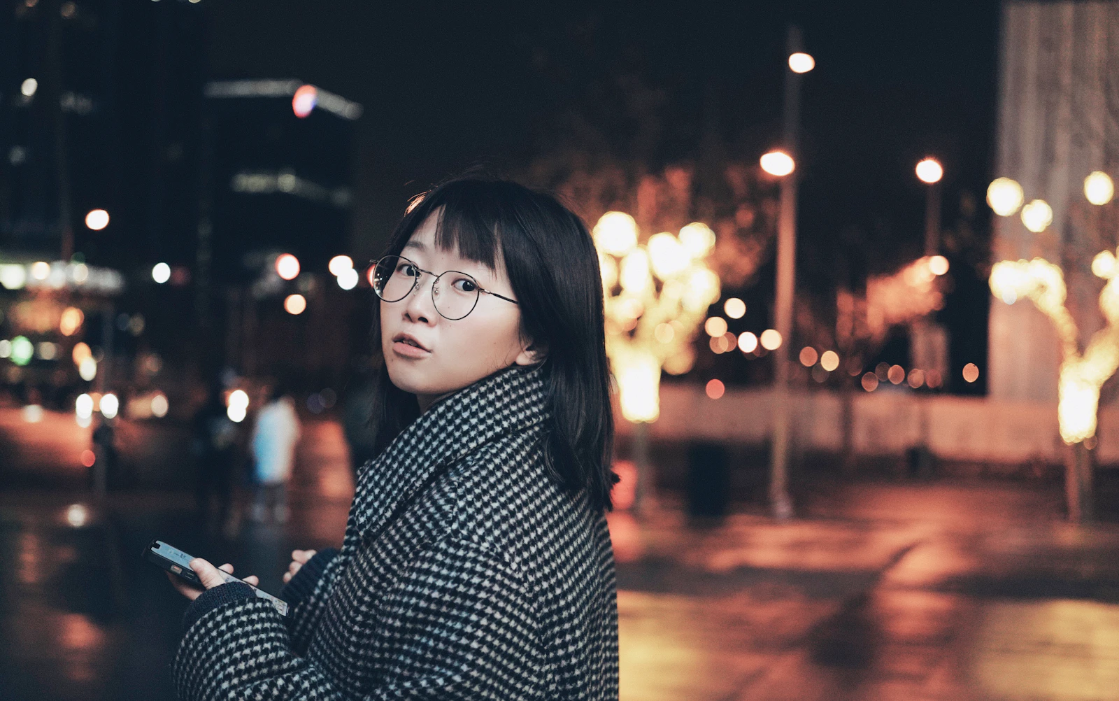 코트를 입고 거리에서 휴대폰을 보는 사람, 손님이 휴대폰으로 검색하는 순간을 떠올리게 하는 장면