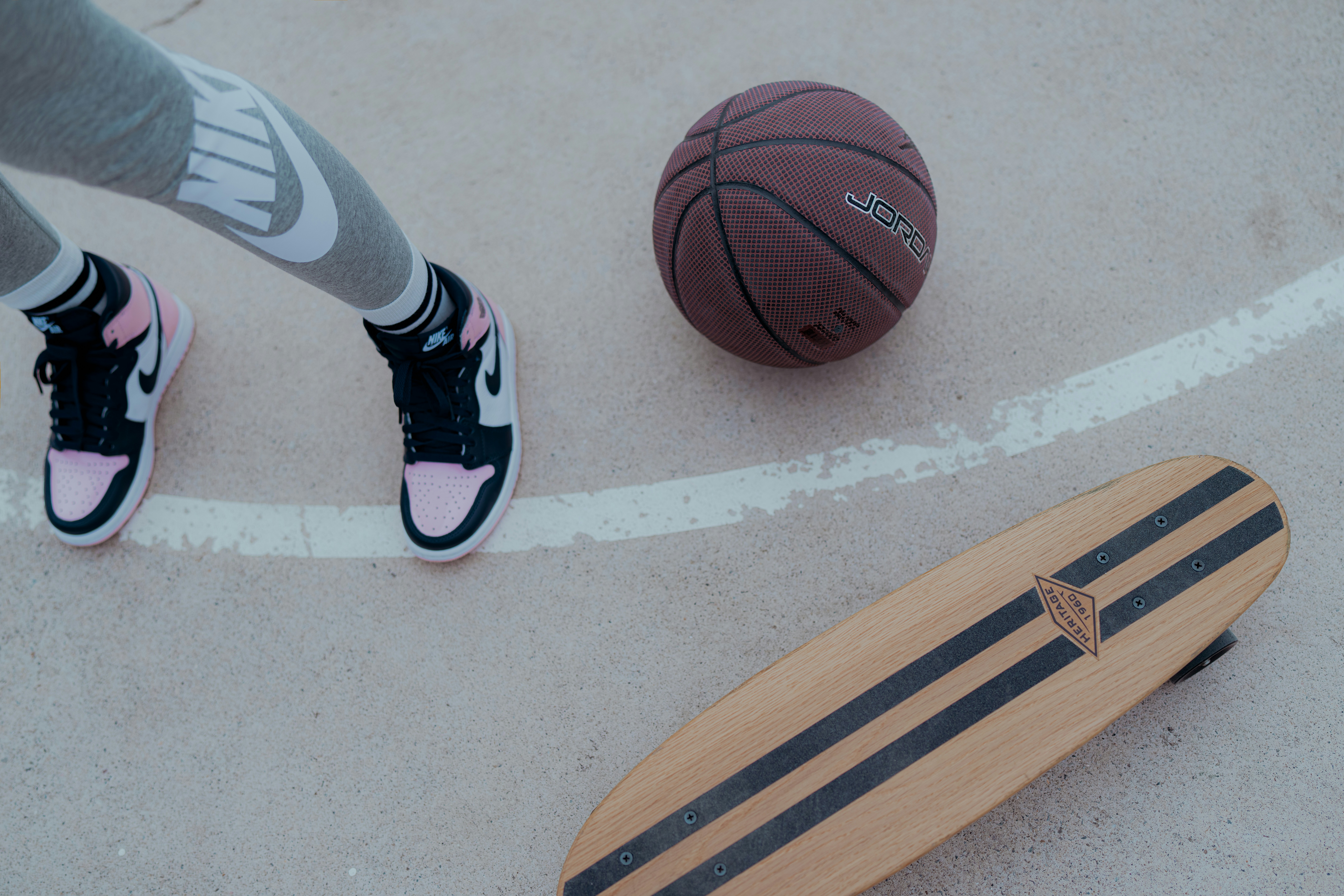 a person standing next to a basketball and a skateboard