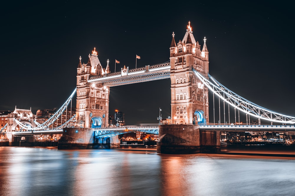 the tower bridge is lit up at night