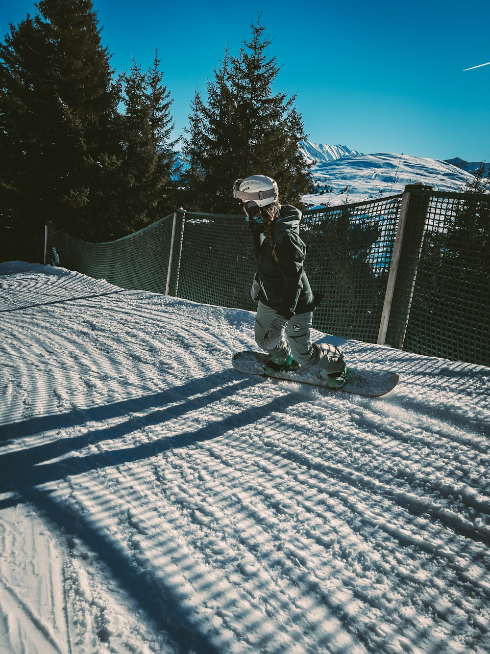 a person riding a snowboard down a snow covered slope