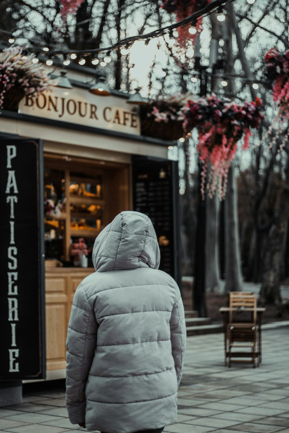 a person walking down a sidewalk in front of a pastry shop