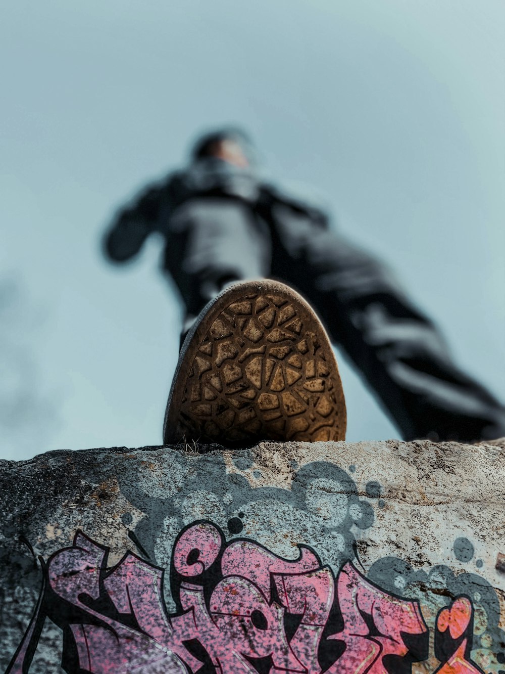 a person standing on top of a rock with graffiti on it