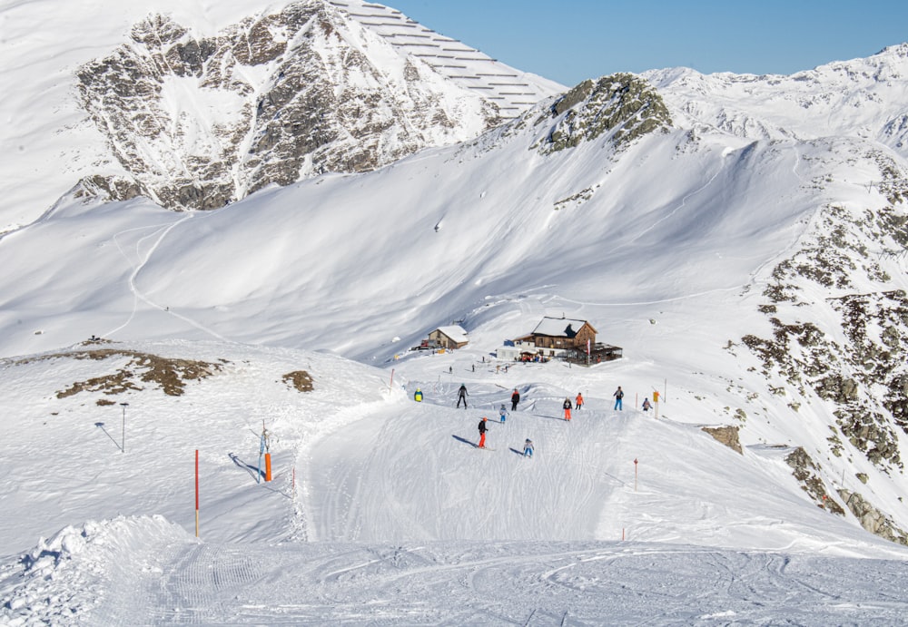 a group of people riding skis down a snow covered slope