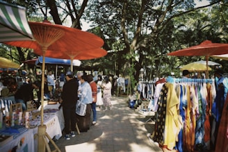 a group of people standing under umbrellas at a market