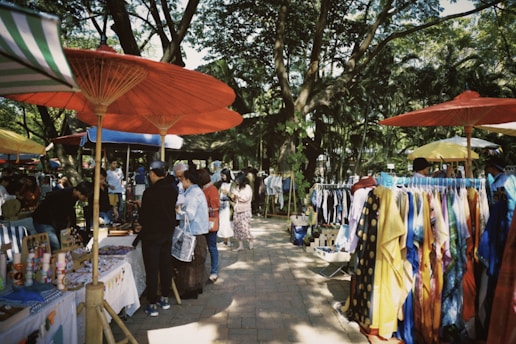 a group of people standing under umbrellas at a market