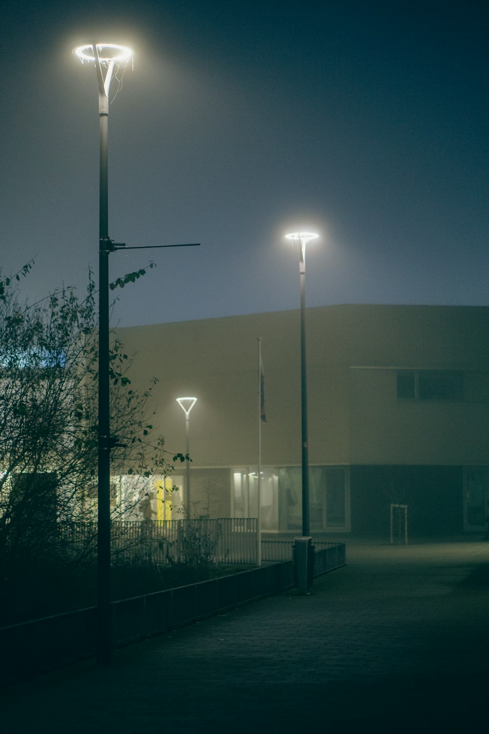 a street light on a foggy night with a building in the background