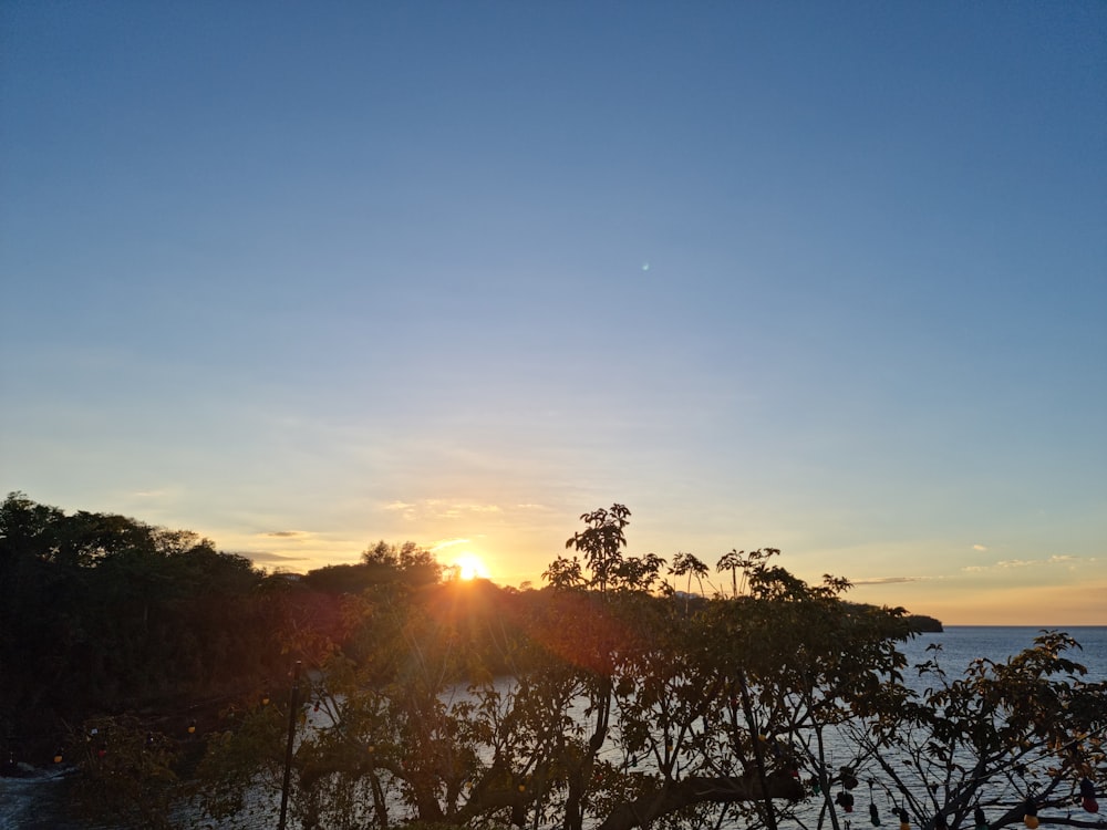 the sun is setting over a body of water