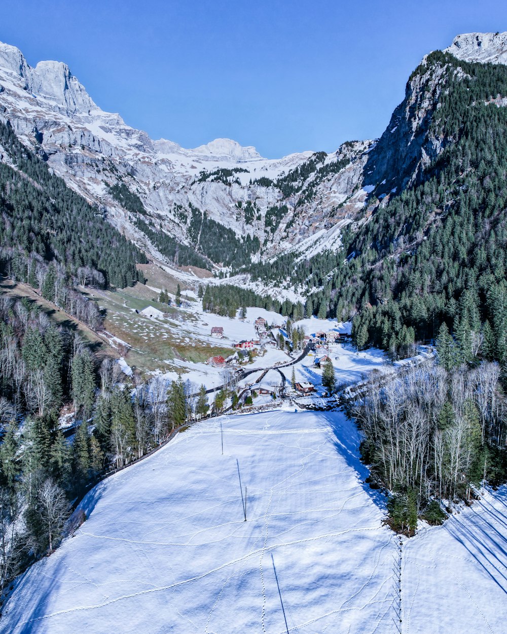 um homem de pé no topo de uma montanha coberta de neve