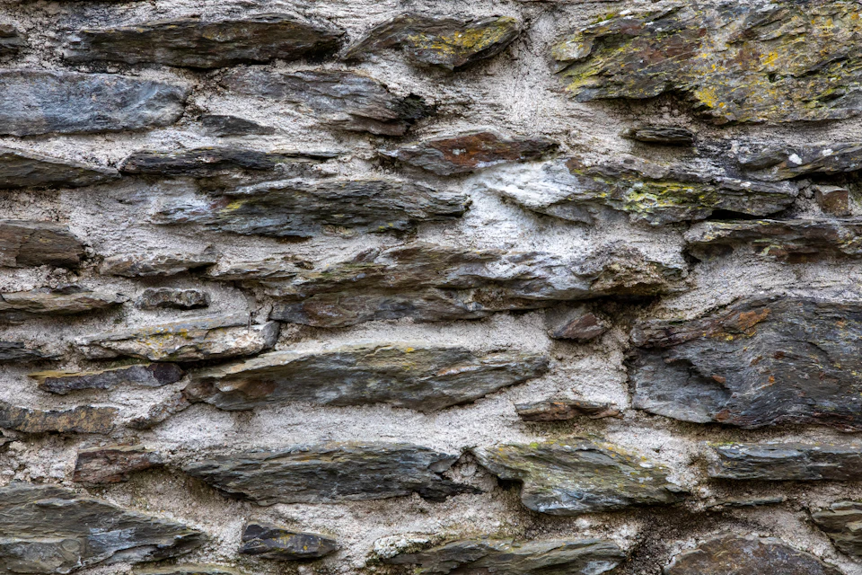 Close-up view of stone wall composed of large, irregularly shaped stones with varying shades