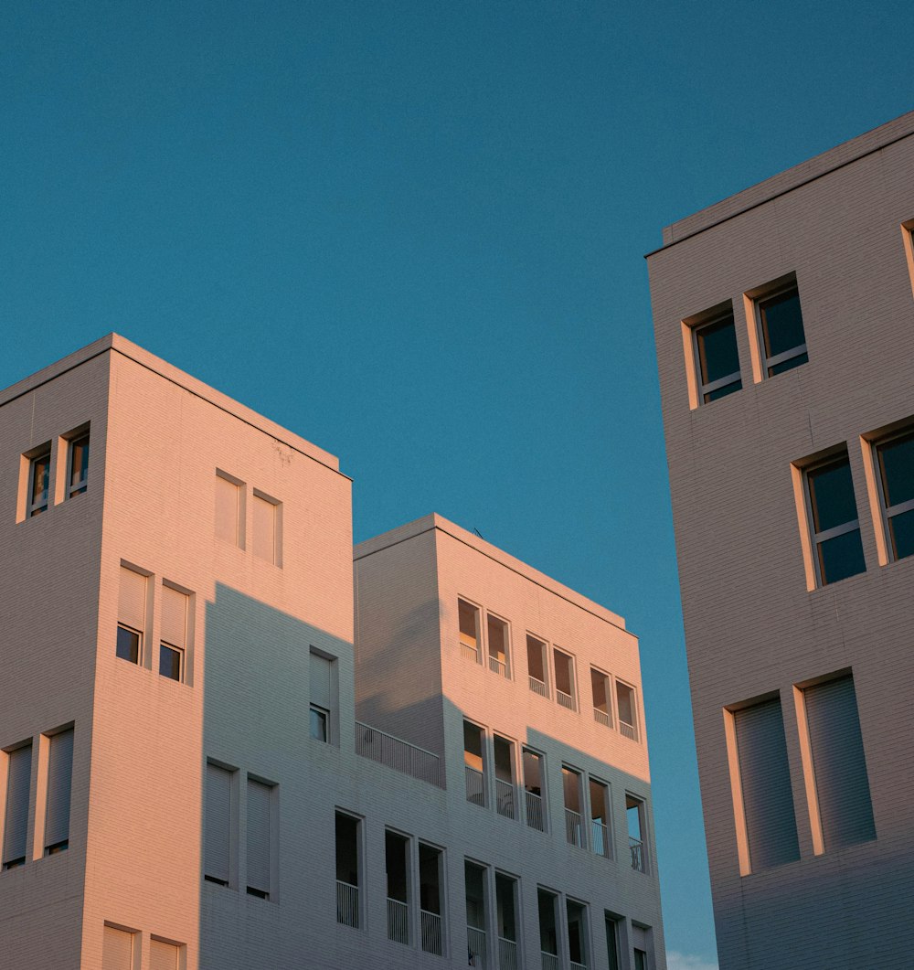 two tall white buildings against a blue sky