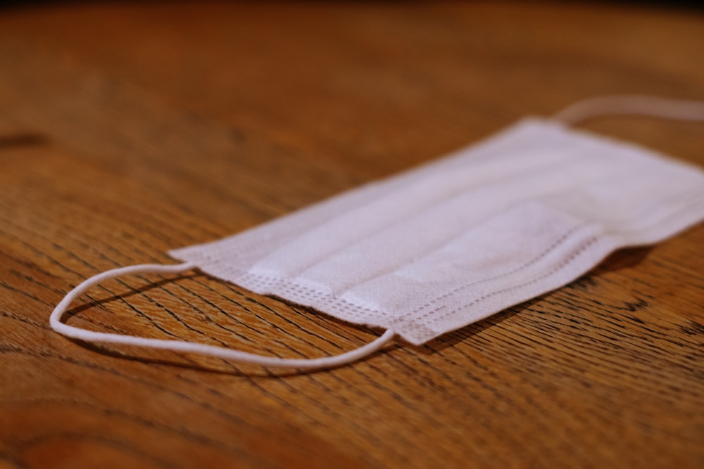 a white face mask sitting on top of a wooden table