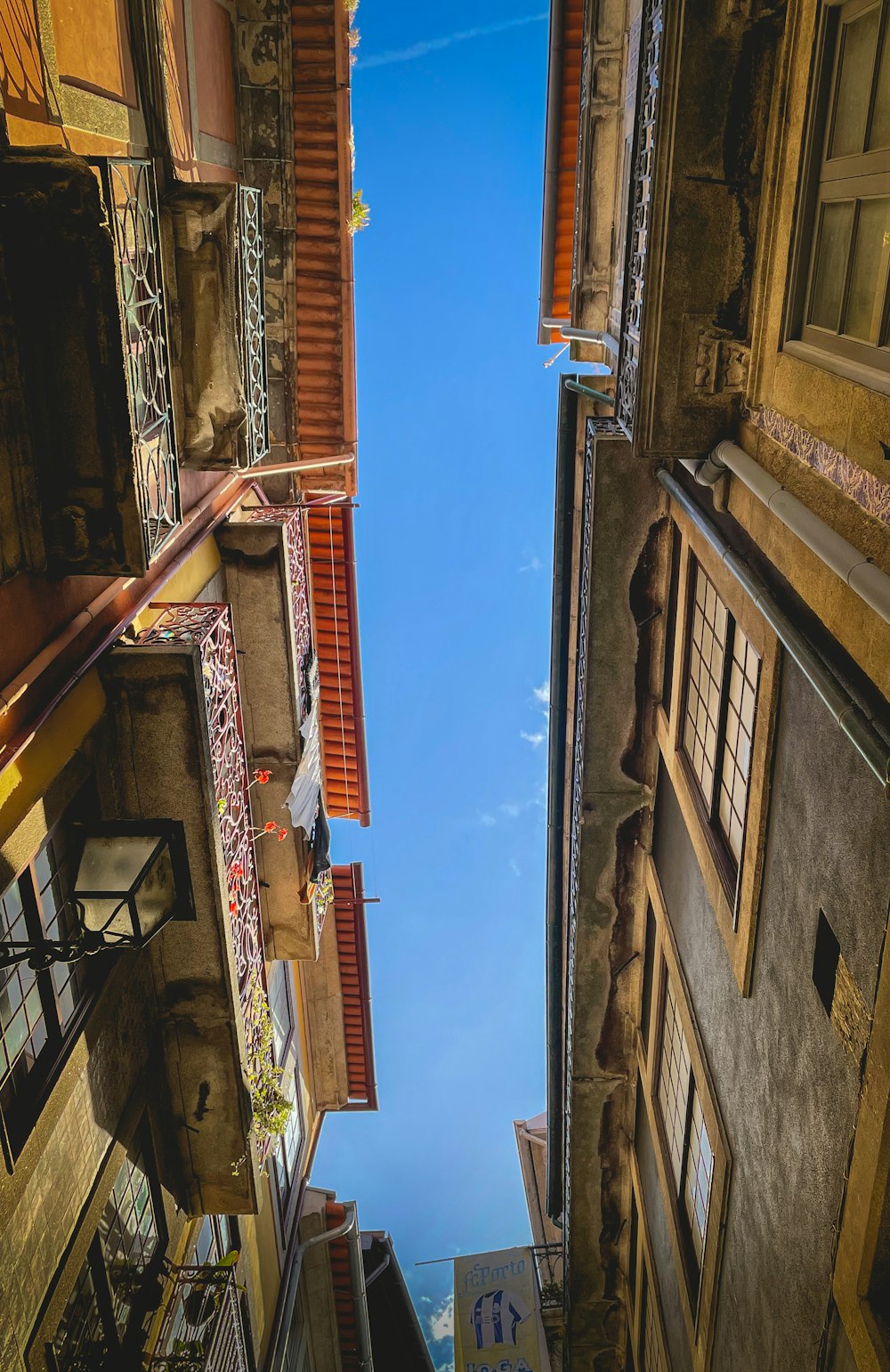 a narrow alley way with a blue sky in the background
