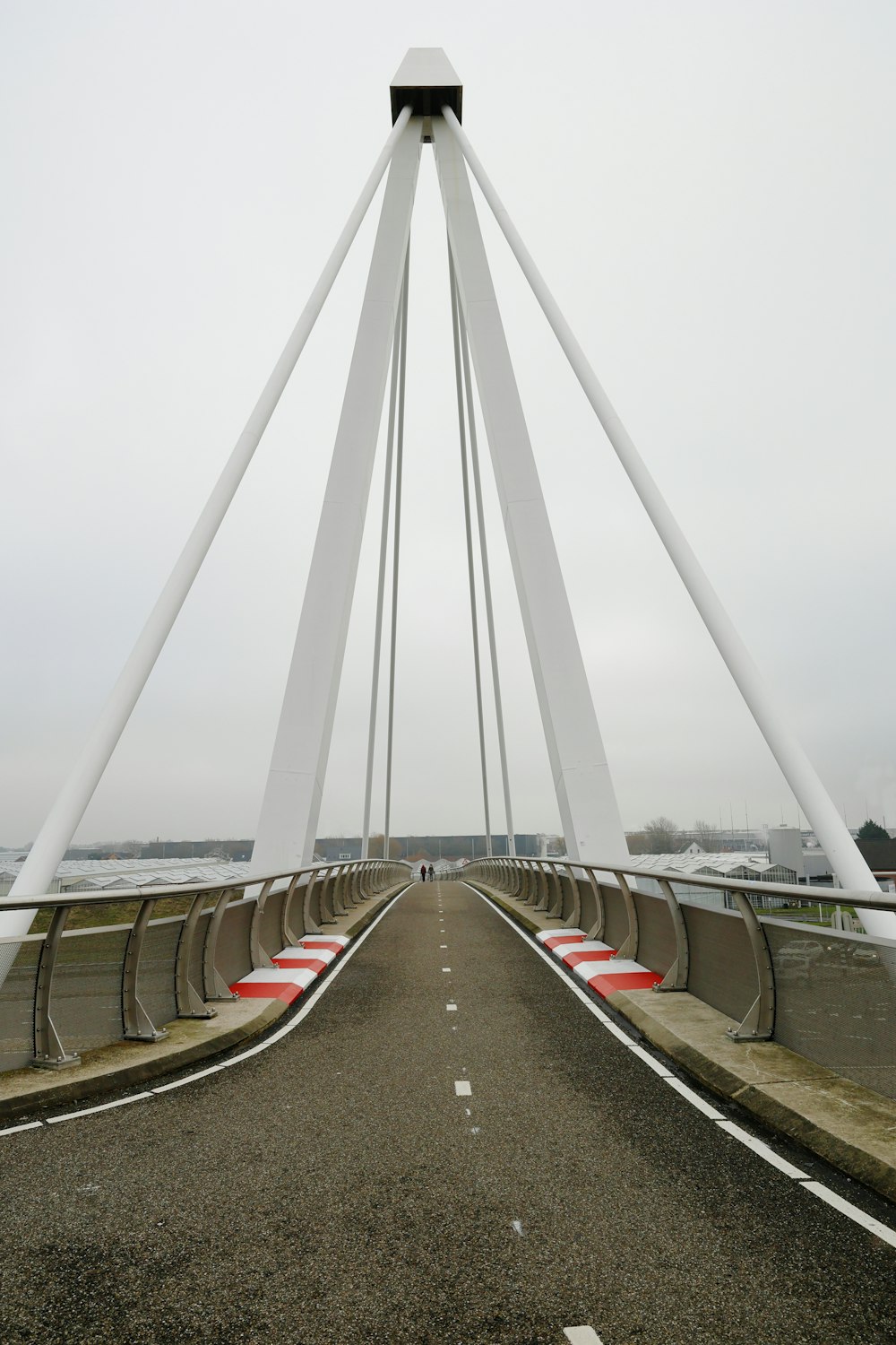 a very tall white bridge over a wide open road