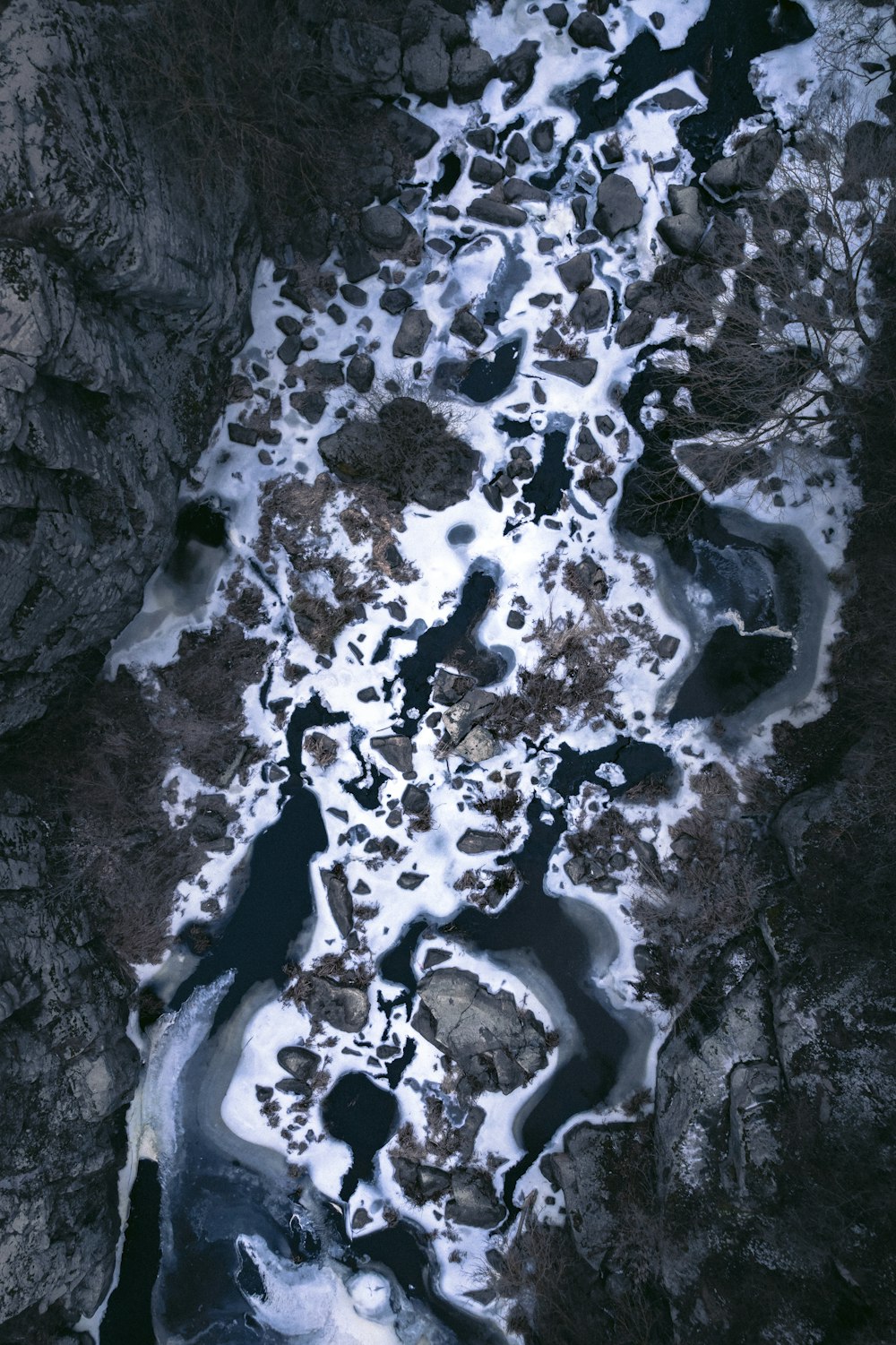 an aerial view of a river running through a rocky area