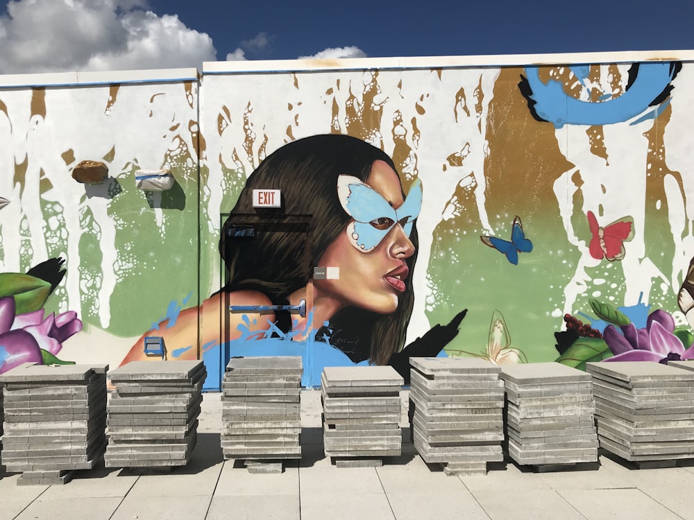 a large mural of a woman with a blue butterfly on her face
