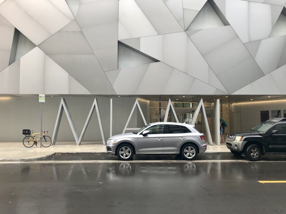dois carros estacionados em frente a um edifício