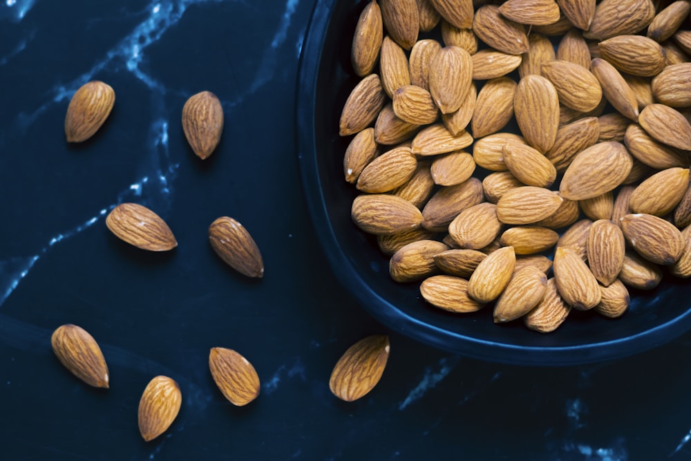 a blue bowl filled with almonds on top of a table