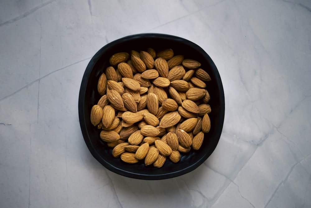 a black bowl filled with almonds on top of a table