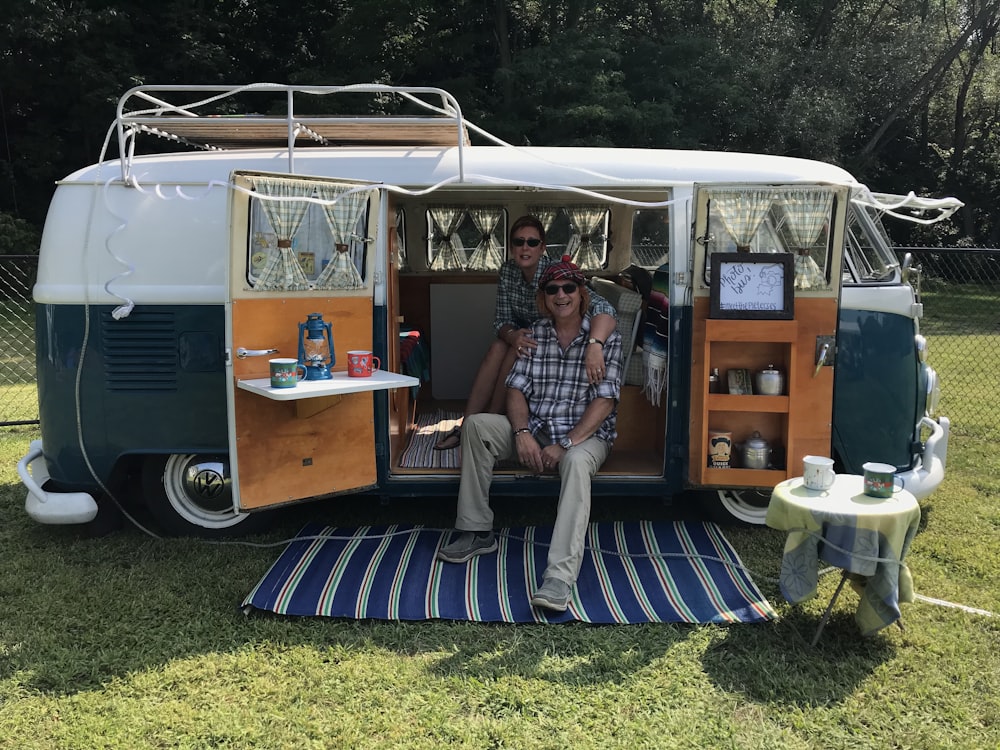 a man and a woman sitting in the back of a van