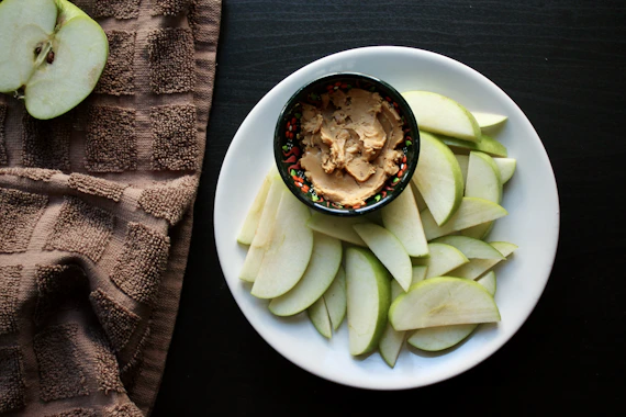 Sliced apples served with a bowl of nut butter
