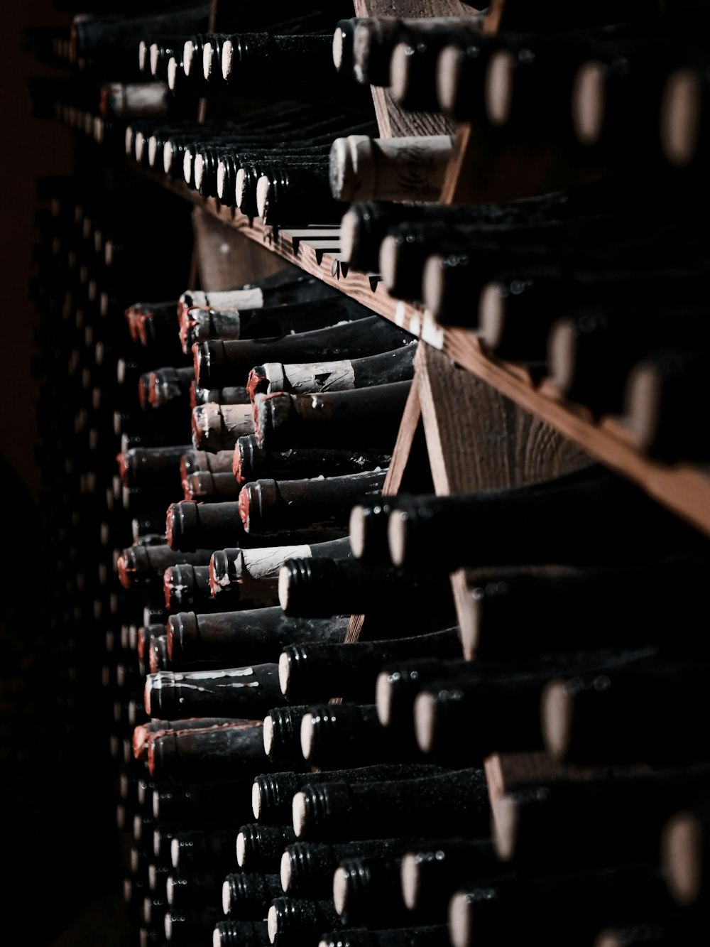 a bunch of bottles of wine are stacked on a shelf