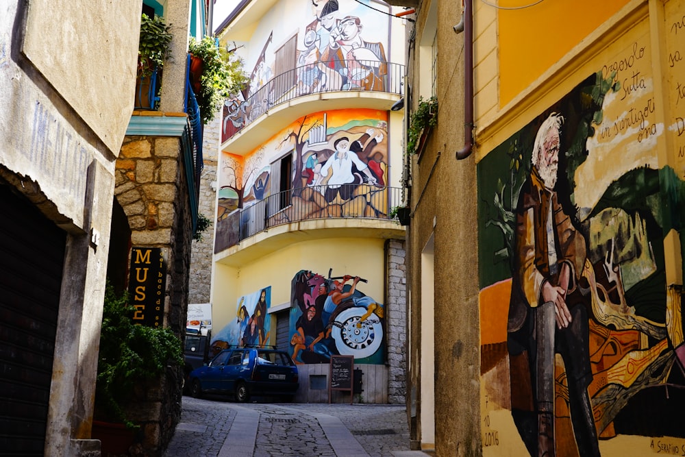 a narrow alleyway with a mural on the side of a building