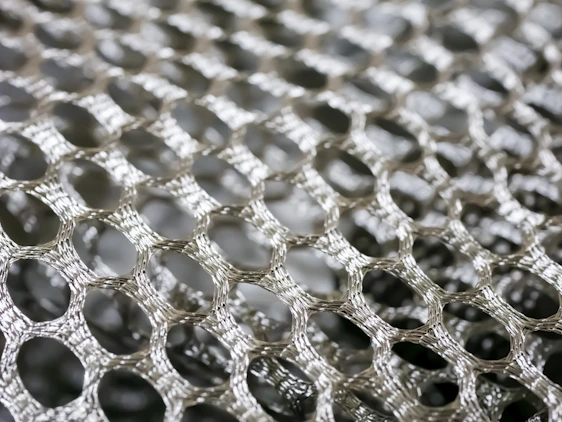 Close-up of a stainless steel filter mesh with fine, precise weaving reflecting light.