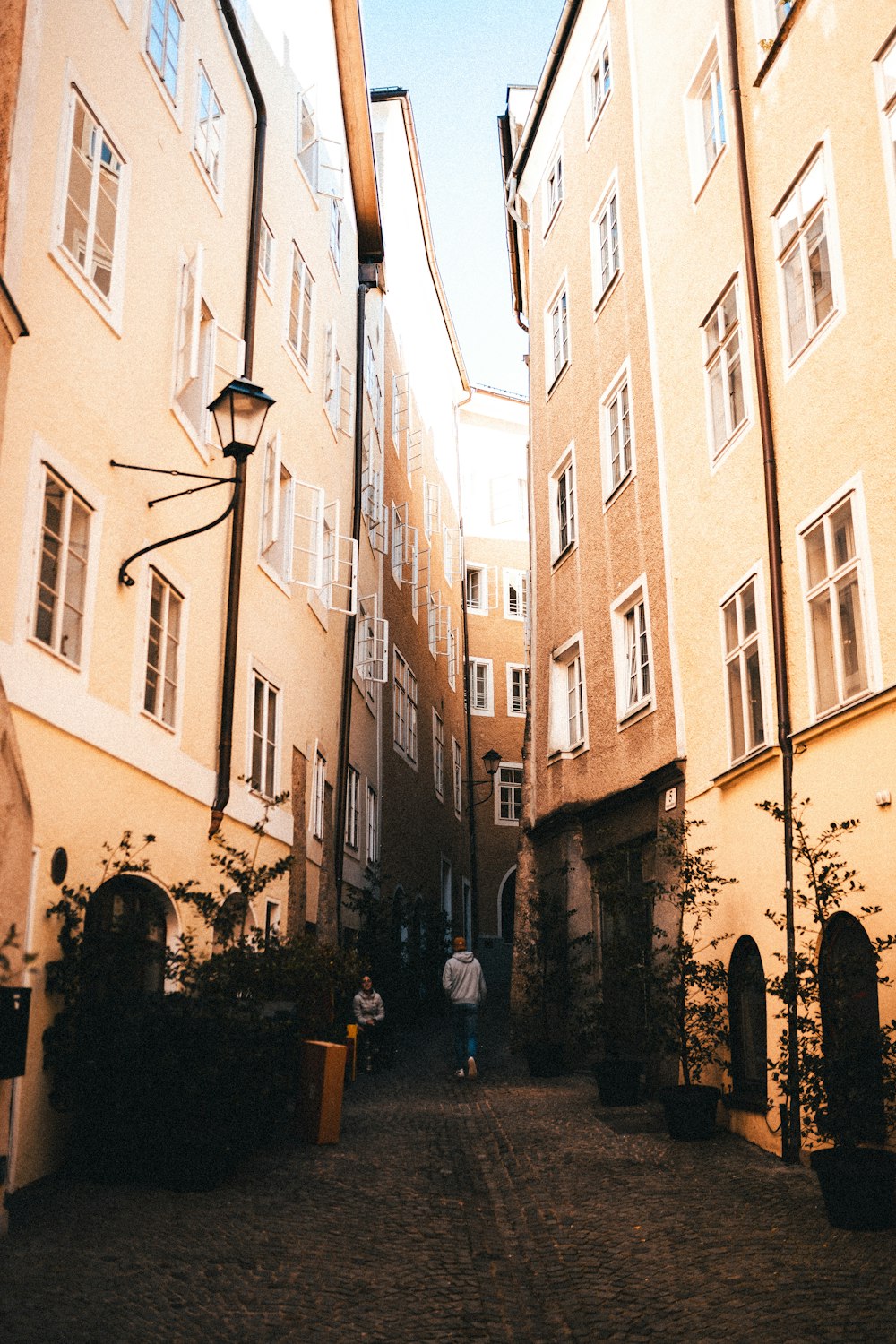 a couple of people walking down a narrow alley way