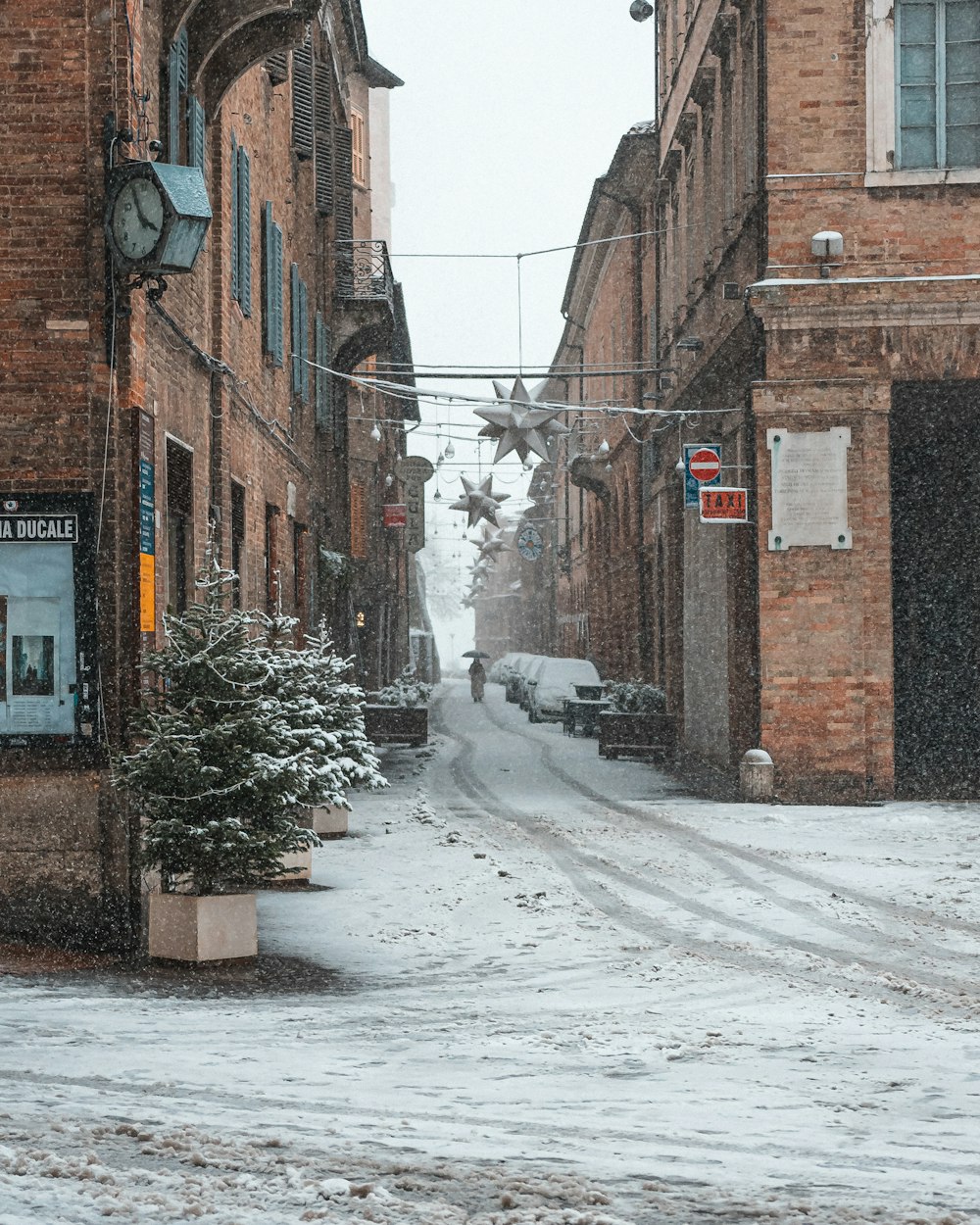 a snowy street with cars parked on the side of it