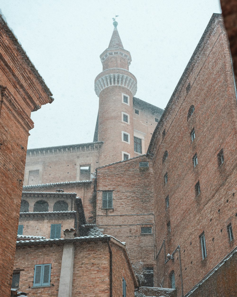 a tall brick building with a clock tower in the background
