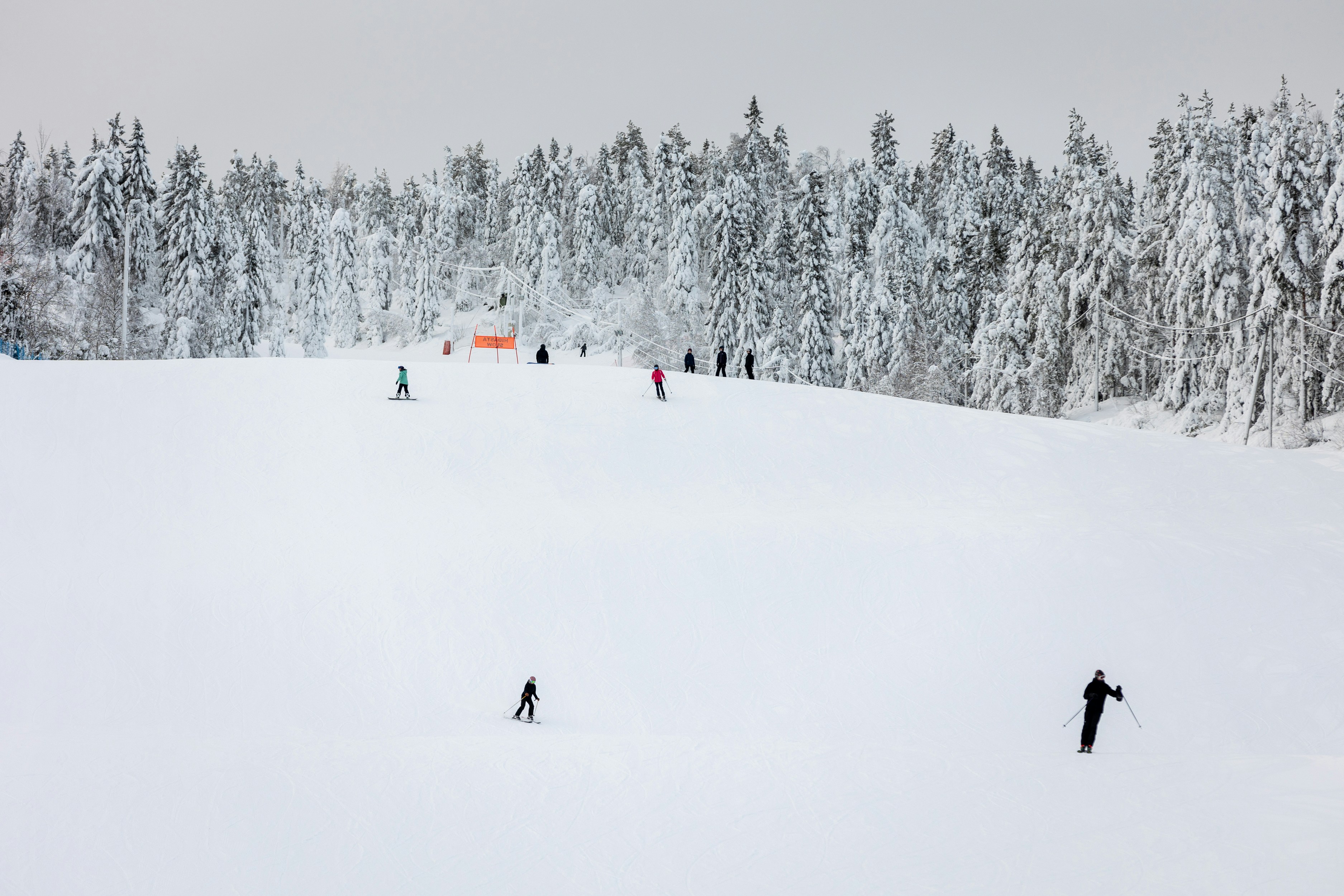 a group of people riding skis down a snow covered slope