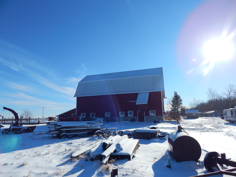 a red barn sits in the middle of a snowy field