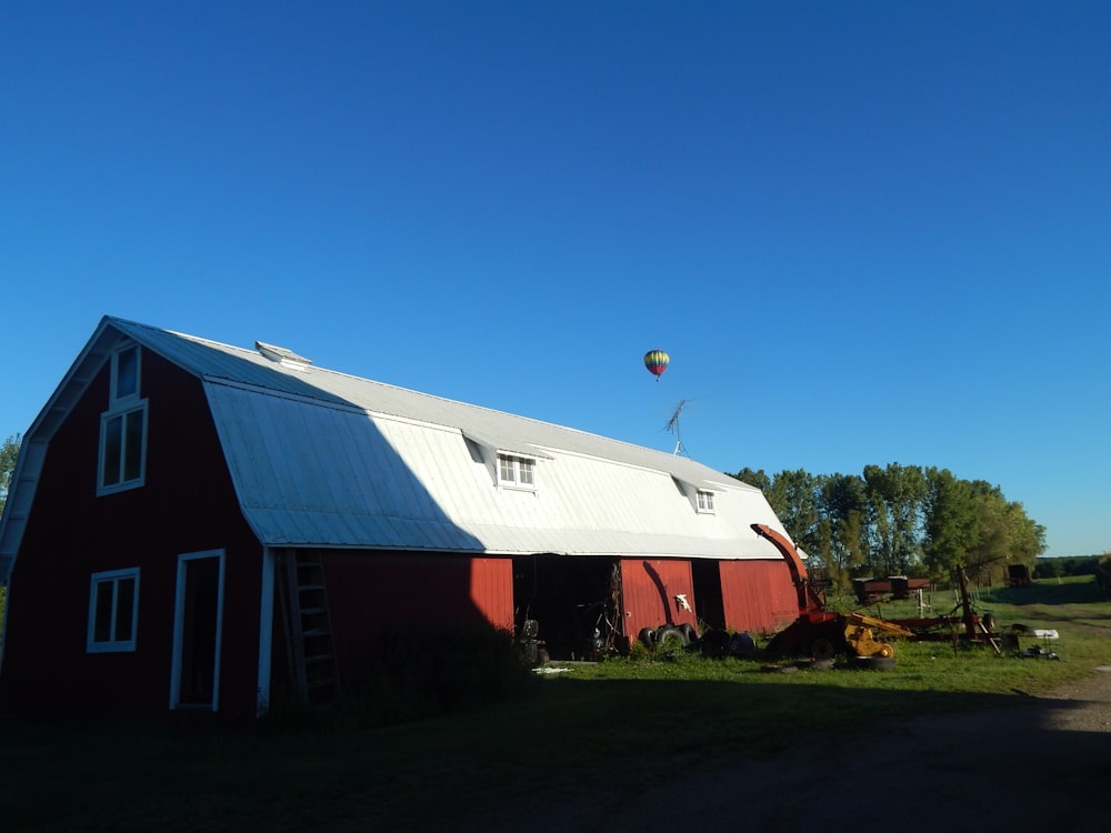 a red barn with a hot air balloon in the sky