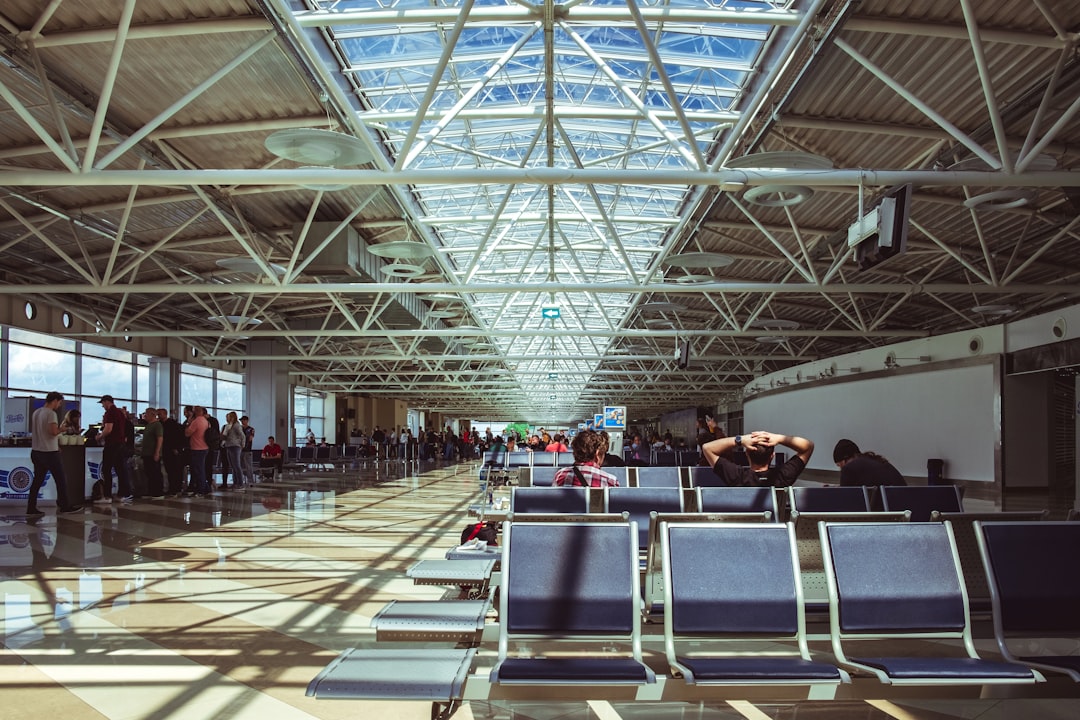 a group of people standing in a waiting area, Waiting for the flight out of Kyiv in this very bright and airy airport. T