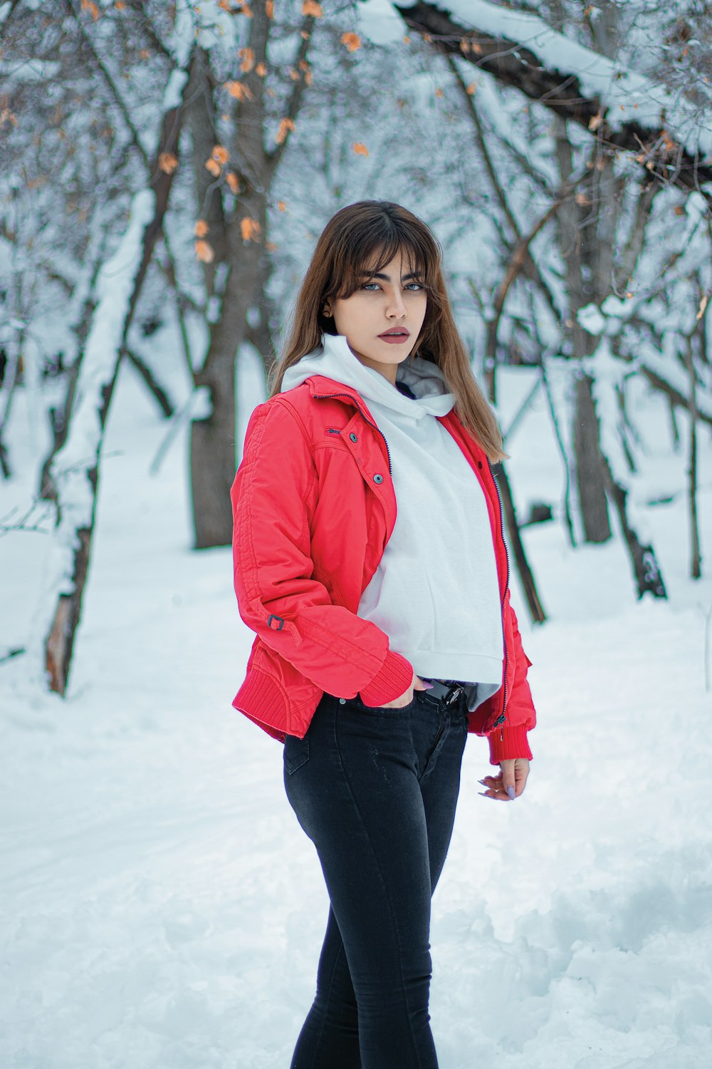 Foto Uma mulher em uma jaqueta vermelha está de pé na neve – Imagem de  Garota grátis no Unsplash