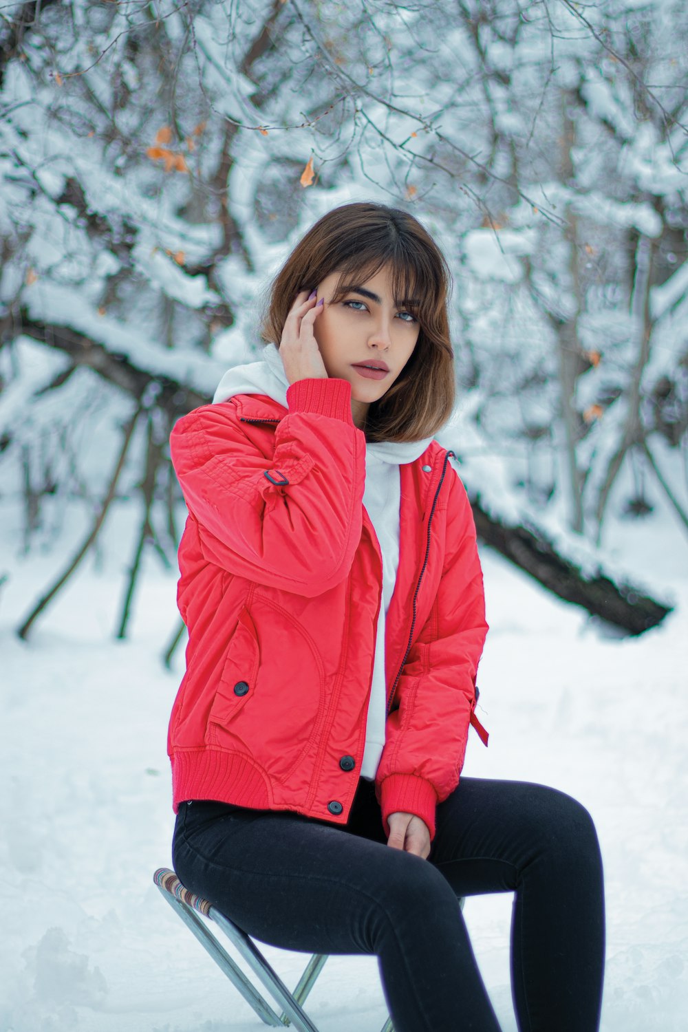 a woman sitting on a chair in the snow