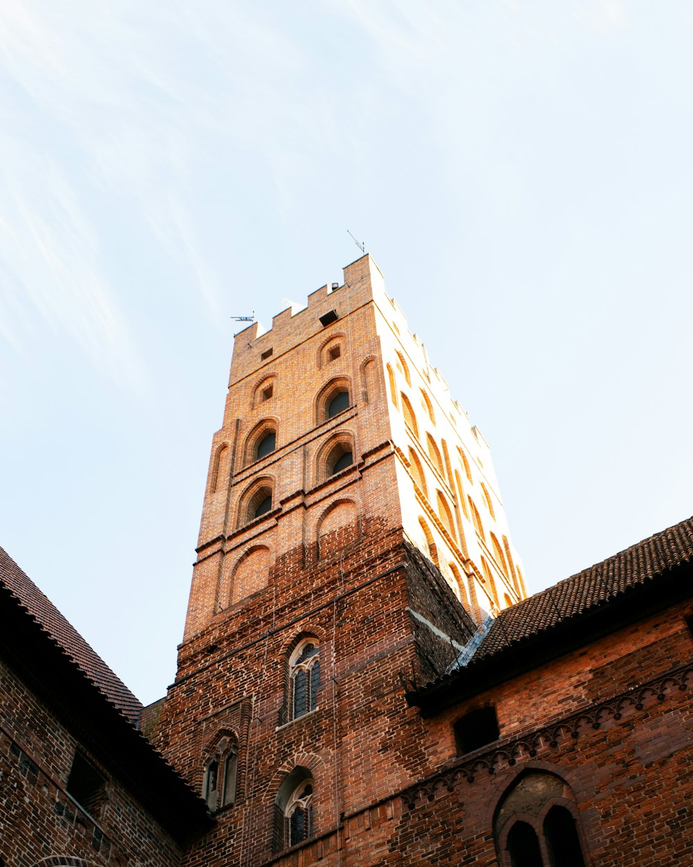 a tall brick building with a clock on it's side