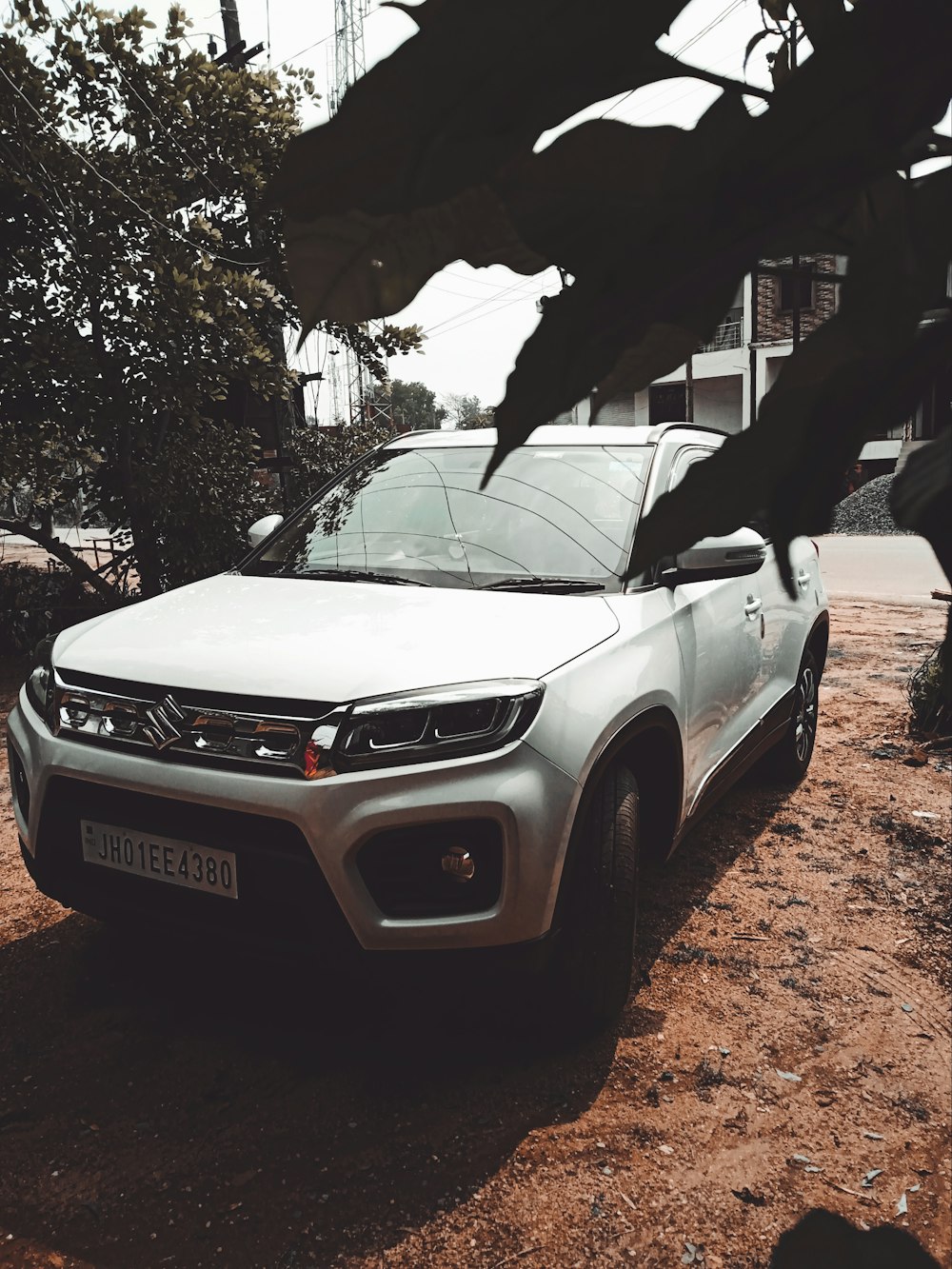 a white car parked on a dirt road