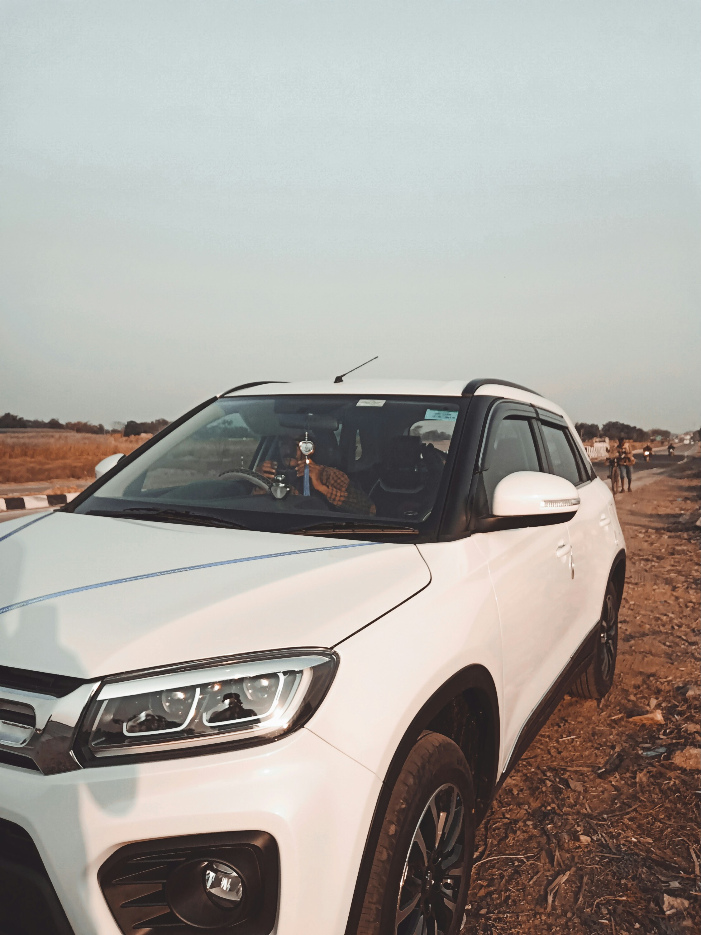 um carro branco estacionado em uma estrada de terra
