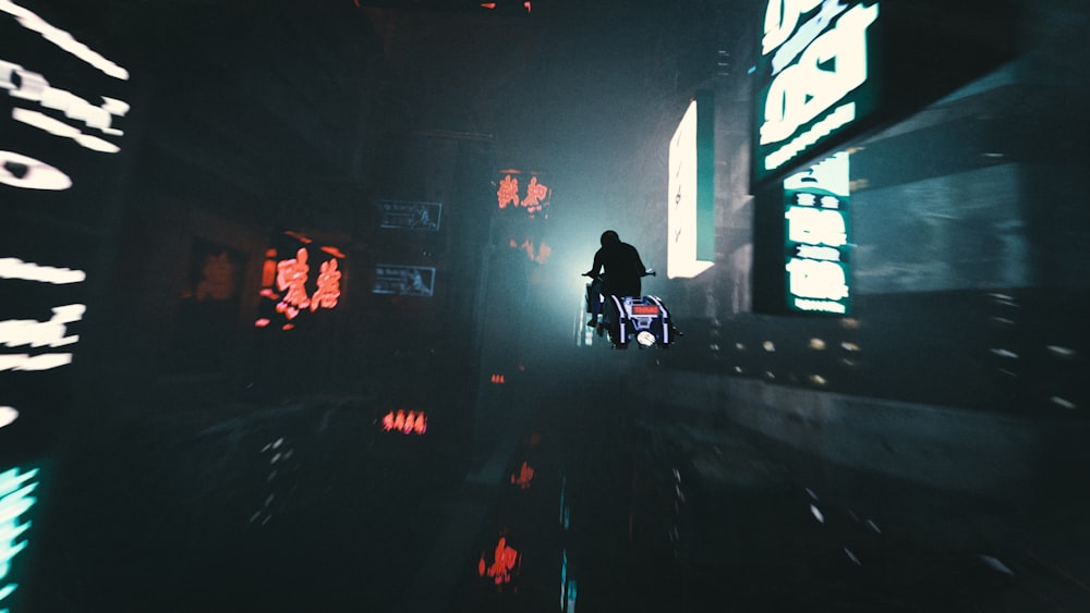 a person riding a motorcycle down a street at night