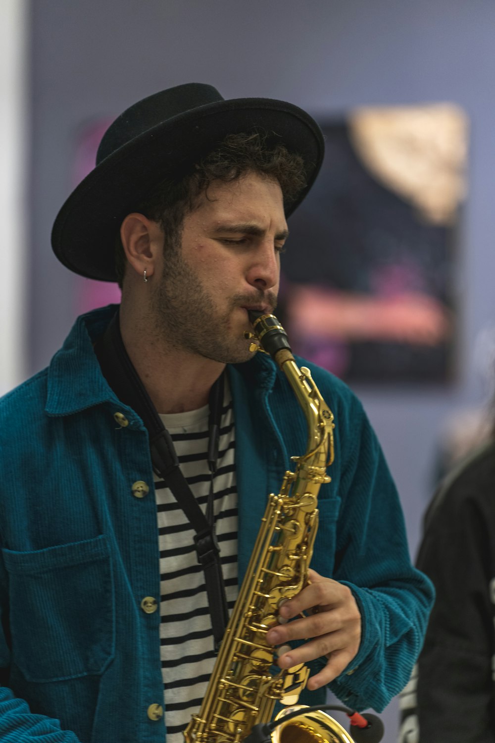 a man with a hat playing a saxophone