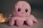 a pink octopus stuffed animal sitting on top of a table