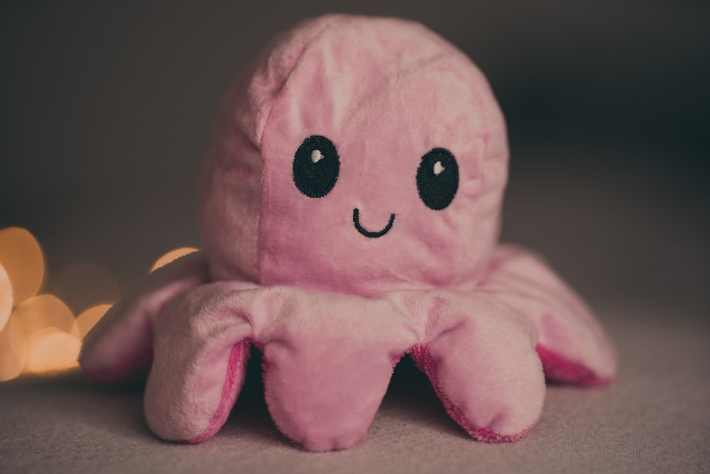 a pink octopus stuffed animal sitting on top of a table